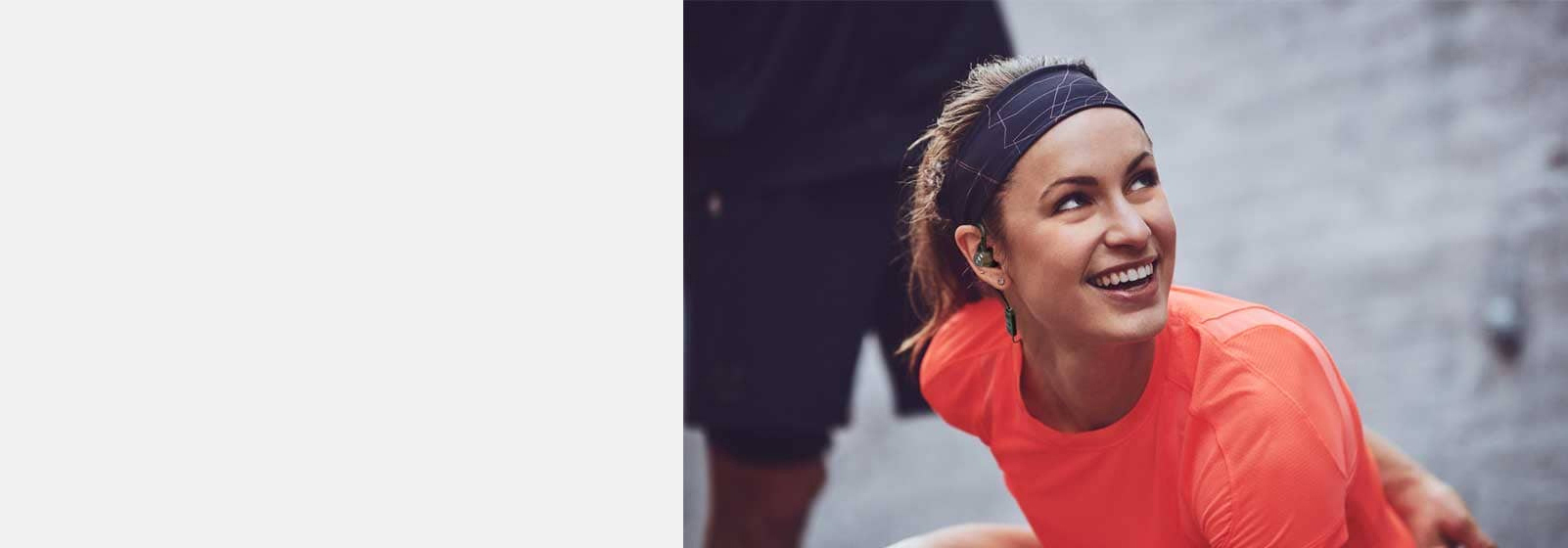 A girl wears JBL Under Armour Pivot in-ear Wireless Sport Headphones