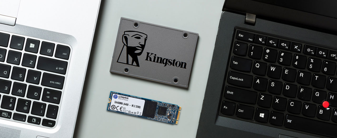 A 2.5” A400 SSD and an M.2 A400 SSD lying between two laptops