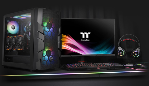 Thermaltake Commander C33 Case Fully Loaded with components next to a gaming monitor, keyboard, headphones and mouse