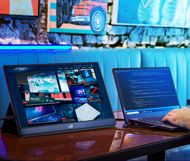 The monitor is next to a laptop.