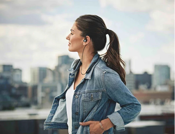 A girl wears IE 80S BT headphones