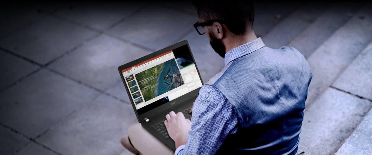 a man making PPT on TravelMate P2 placed on his thigh