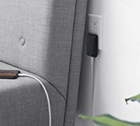Anker PowerPort Atom III Slim plugged into an outlet behind a sofa