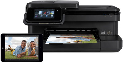 A printer outputting a photo, and in front of it is an iPad Air with its screen showing the printed photo