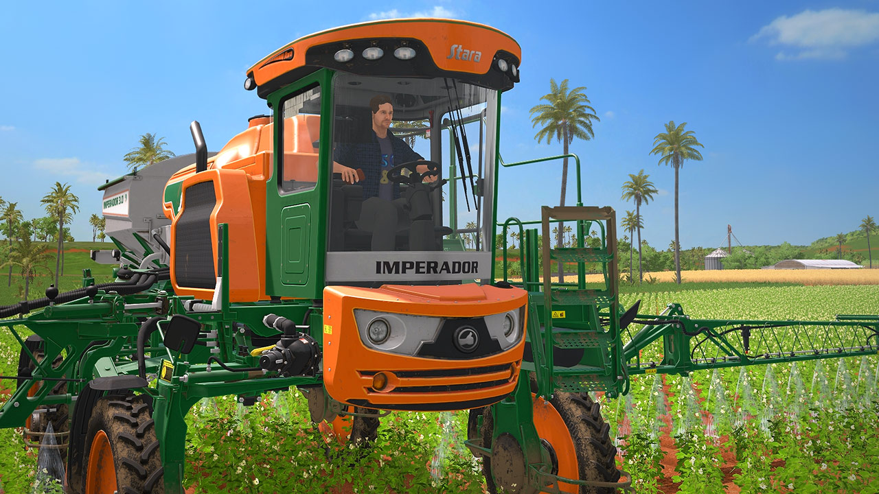 A man operating an orange and green field cultivator driving over a field of crops