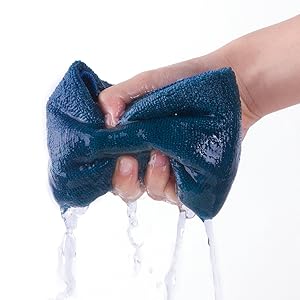 a hand holding a blue cloth with water flowing down it.
