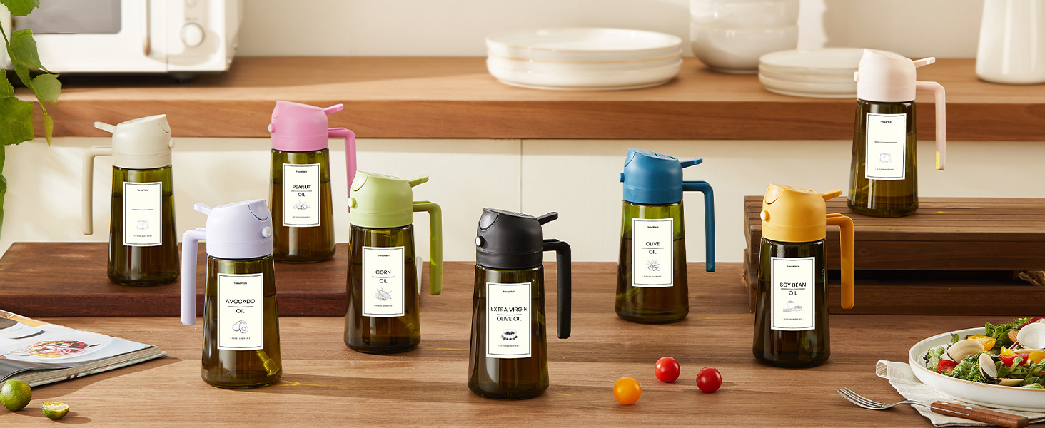 Collection of colorful glass bottles with pump dispensers on a wooden surface. Bottles have white labels and contain various liquids.