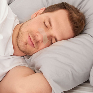 Person peacefully sleeping on white bedding, demonstrating comfortable rest position.