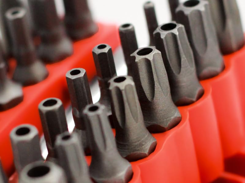 Extreme macro close-up shot of three or four security bit tips arranged side by side at a slight dia