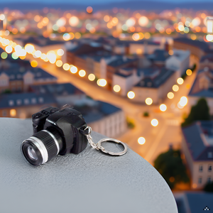 A close-up view of a miniature camera keychain resting on a wooden surface, surrounded by colorful b
