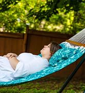 Blue tropical quilted hammock with detachable pillow and wooden spreader bar female model laying
