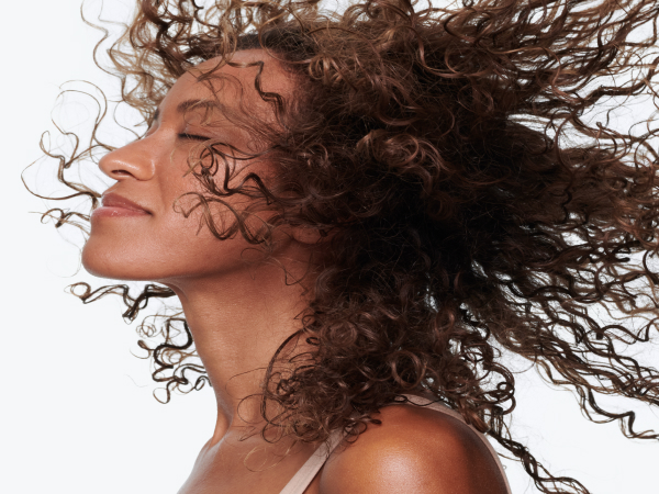 Woman smiling with curly, healthy-looking hair.