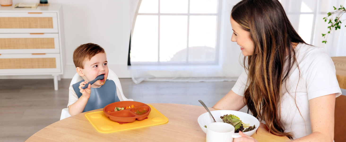 Baby eating independently with Prep silicone placemat and bowl during everyday mealtime at home