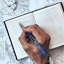 Photo shows person travel journaling with a G2 Extra Fine pen