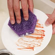 Kitchen sponge removing food residue from plate