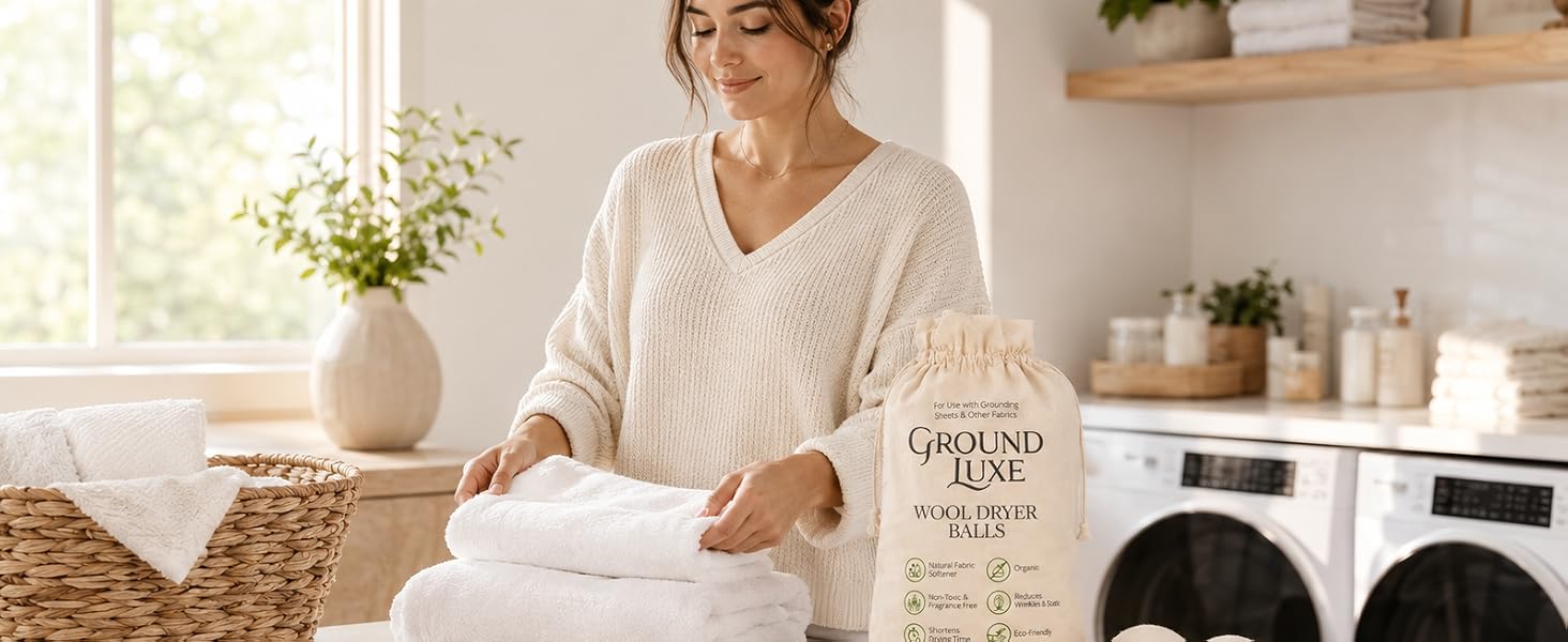 Woman folding soft towels with wool dryer balls in a bright laundry room