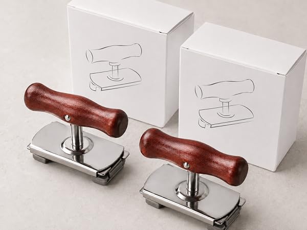 close view of two red-brown wood handle jar openers and white boxes