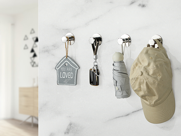 Wall-mounted key and hat organization system with multiple hooks holding various items including a house-shaped key holder.