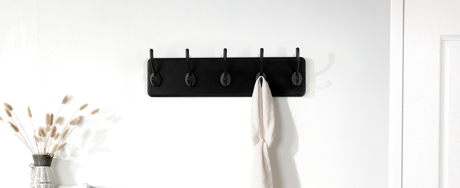 There is a black wall-mounted coat rack with 5 hooks at the entrance to the warehouse