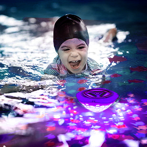 a child in a swimming pool with a disc.