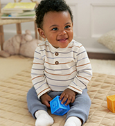 baby boy wearing stripe bodysuit and blue pants