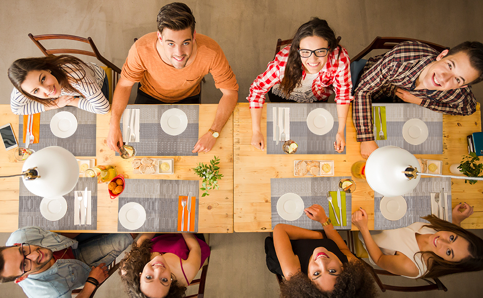 a group of people sitting at a table with plates and place settings