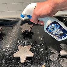 Spraying MiracleSpray for Cooktops and Microwaves