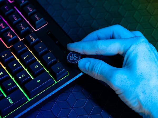 A hand twisting the media dial on the corner of the nightfall keyboard