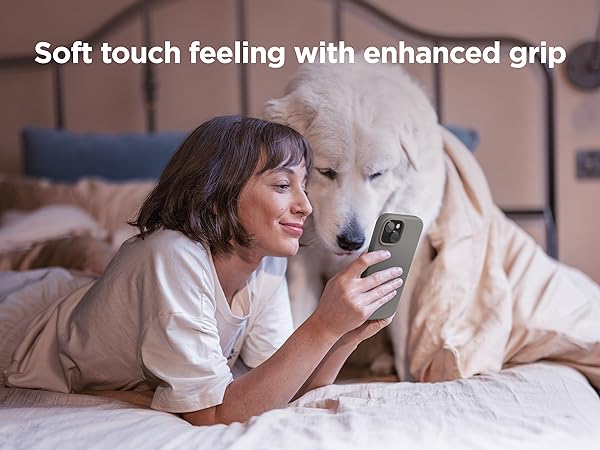 Woman using smartphone with enhanced grip case while lying on bed with large white dog. Text overlay: 'Soft touch feeling with enhanced grip'.