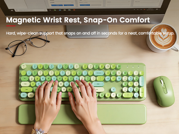 Hands typing on green keyboard with magnetic wrist rest and mouse on wooden desk