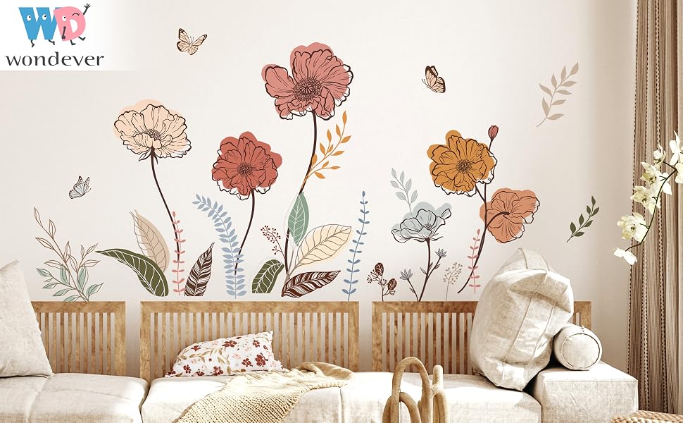 Wall decal set featuring large floral designs in shades of orange and brown. Butterflies and stems included. Displayed on white wall above furniture.