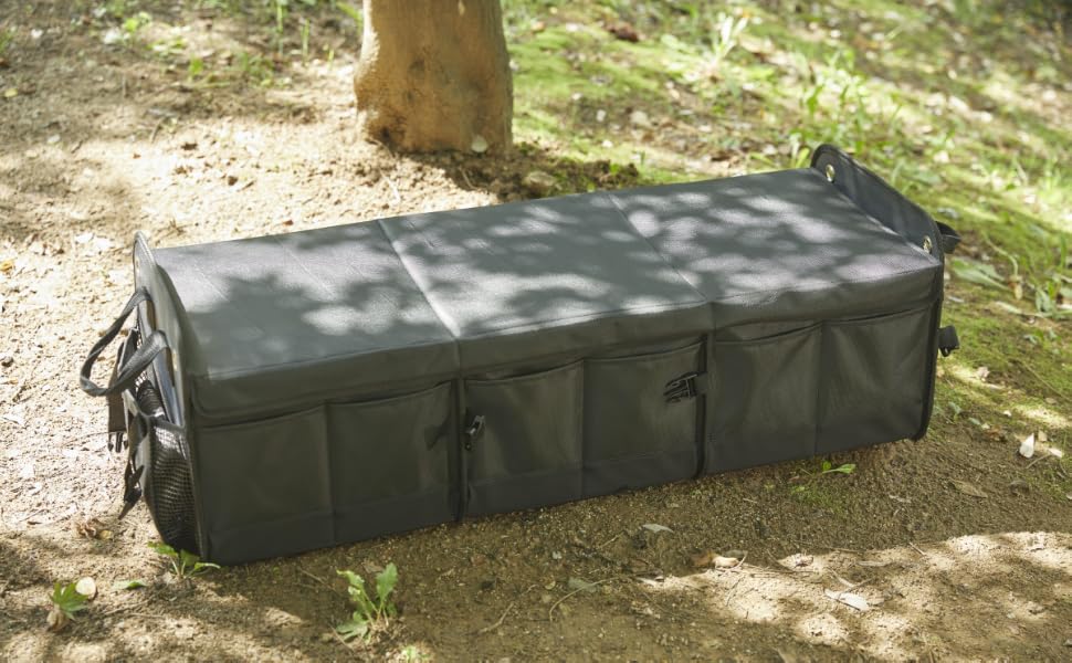 Closed black NINEDUCK trunk organizer outdoors with the included lid and exterior pockets visible.