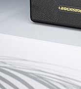 Corner of a black textured electronic device or speaker with 'BOCASING' printed in gold lettering on its surface.