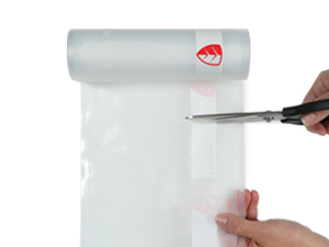 Hands cutting a clear roll with scissors