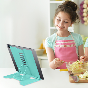 Teal tablet stand on a table, supporting a device in landscape orientation. Sturdy design with adjustable viewing angles.