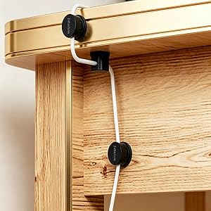 Jebaion magnetic cable organizer arranges cables along the corner of the table.