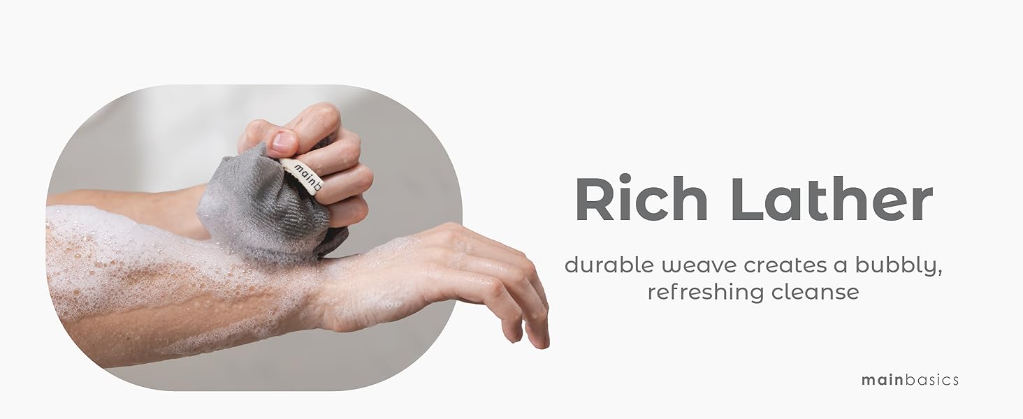 Hands lathering a textured washcloth, creating a foamy cleanse.