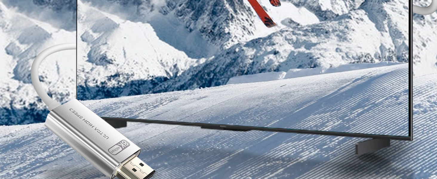 Silver USB device displayed against snowy mountain background with a black electronic device or screen visible in the composition.