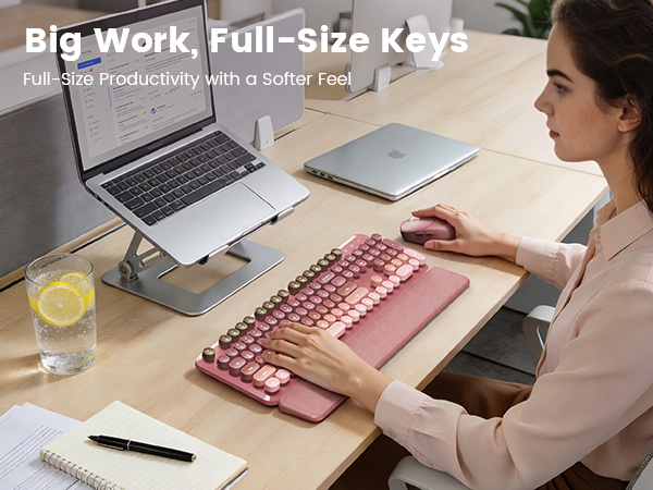 Pink wireless keyboard mouse combo on desk with laptop stand wrist rest for daily work