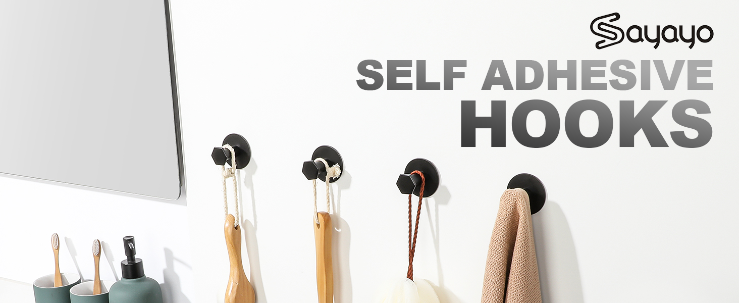 Self-adhesive wall hooks displayed on white surface. Circular black hooks holding various items including clothing, accessories, and a spray bottle. Product name 'Sayayo' visible.