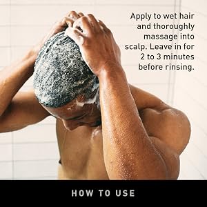 a man in a shower with his arms sprinkled with shampoo.