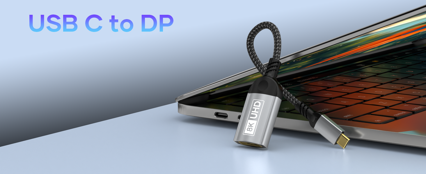 USB-C to DisplayPort adapter cable with braided cord and labeled connector ends, shown against laptop background.