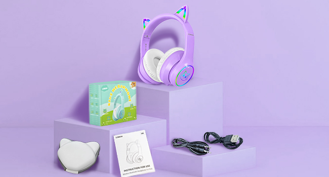 Lavender-colored gaming headset displayed on purple background with accessories including cables and product packaging on stepped display.