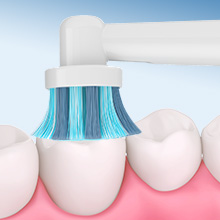 Pink and white toothbrush heads arranged in a pattern against a pink-tinted background, showcasing dental hygiene products.