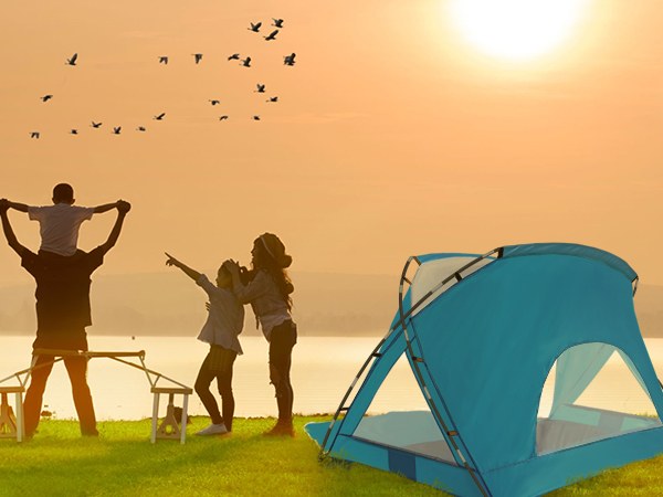 A family of three watching the sunset next to the tent