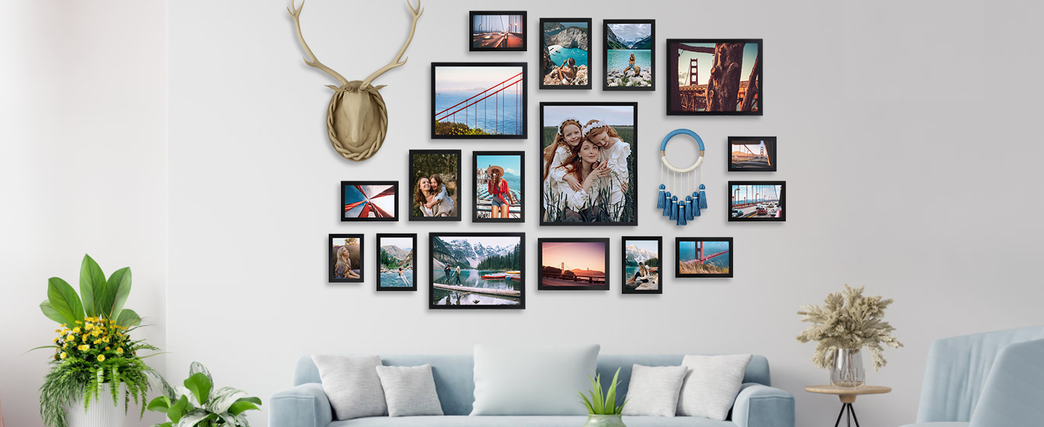 Gallery wall arrangement featuring multiple black-framed photographs in various sizes, organized in artistic cluster pattern with decorative antler accent.