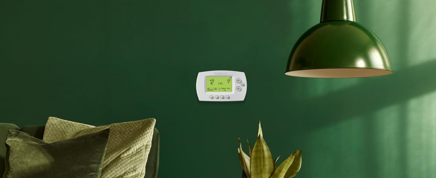 Wi-Fi 7-Day Programmable Thermostat on a green wall