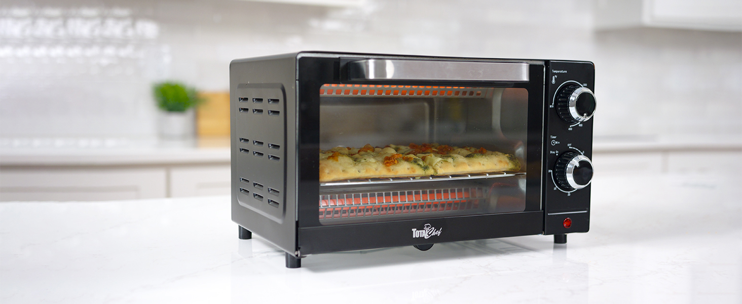 Total Chef toaster oven with food inside on a white marble counter with a plant beside it