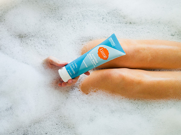Lume Acidified Body Wash in Unscented being used in a bath tub
