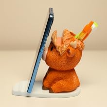 Highland cow phone stand holding smartphone vertically